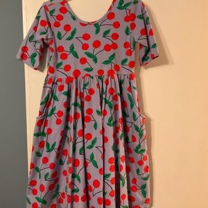 Hanna Andersson Girls Sundress W/Cherry Print and blue background.